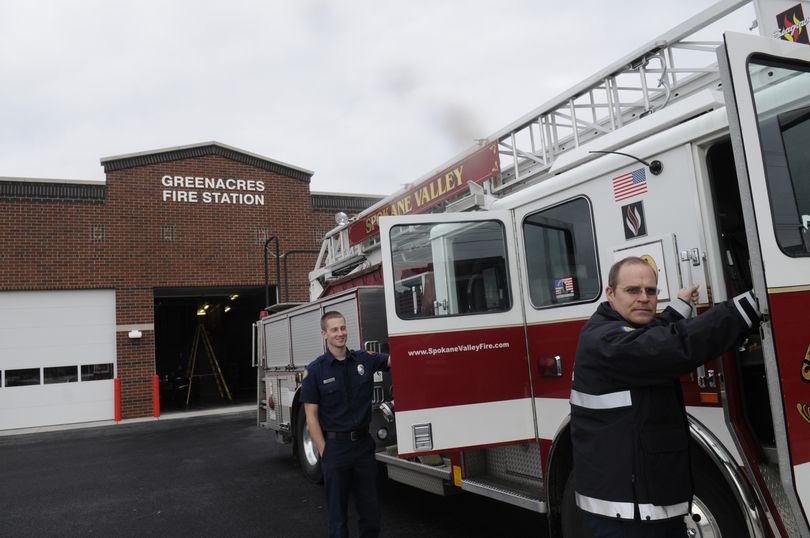 Capt. Mark Hill, right, and firefighter Brad Huffman stand by their truck Tuesday. They are part of the crew that will staff the new Greenacres Fire Station at 17214 E. Sprague Ave.   (Jesse Tinsley)