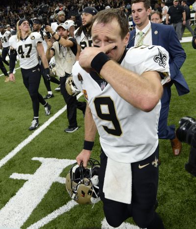 New Orleans Saints quarterback Drew Brees (9) wipes his eyes as he crosses the field after an NFL football game in New Orleans, Monday, Oct. 8, 2018. Brees broke the NFL all-time passing yards record during the game. The Saints won 43-19. (Bill Feig / Associated Press)