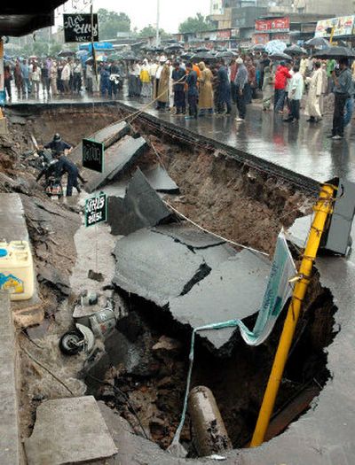 
Firefighters prepare to retrieve scooters after a road collapsed in Ahmadabad, India. 
 (Associated Press / The Spokesman-Review)