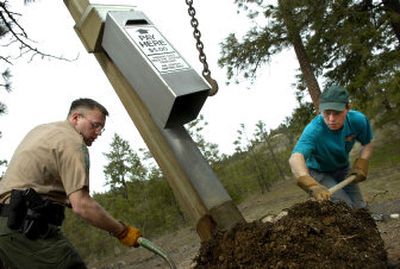 
Ranger Jody Maberry, left, and Dan Varnell of the Washington Conservation Corps knock the dirt from a pay station as it is removed from the ground near the Bowl and Pitcher in Riverside State Park on Thursday afternoon.
 (Holly Pickett / The Spokesman-Review)