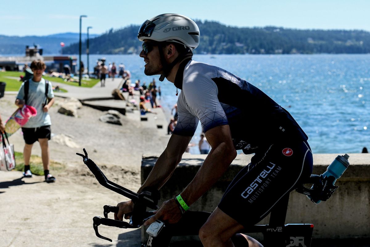 A cyclist pedals past City Beach in Coeur d’Alene on Thursday as the city gets ready to host Ironman Coeur d’Alene on Sunday.  (Kathy Plonka/The Spokesman-Review)