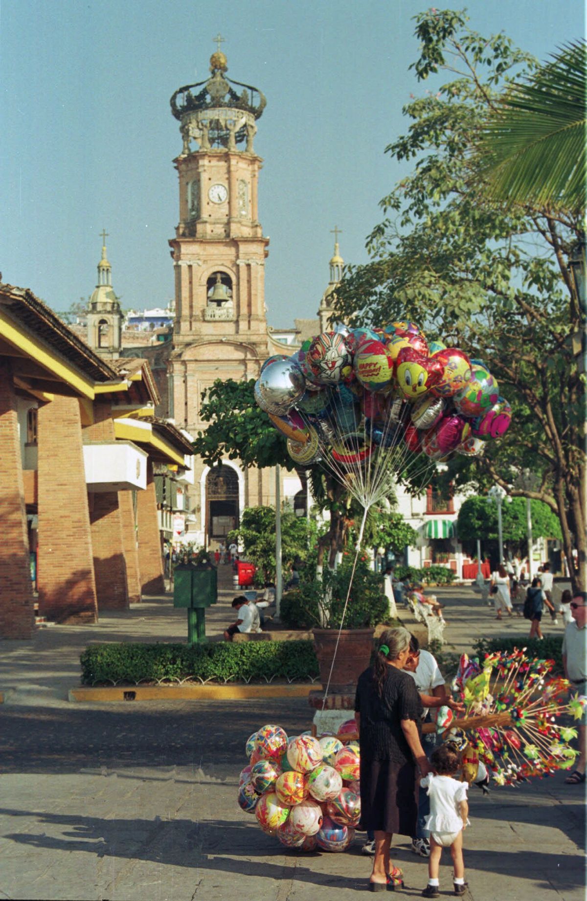 Customers make a purchase from a balloon vendor  in Puerto Vallarta, Mexico, in front of the city’s landmark Catholic church.  (Associated Press / The Spokesman-Review)