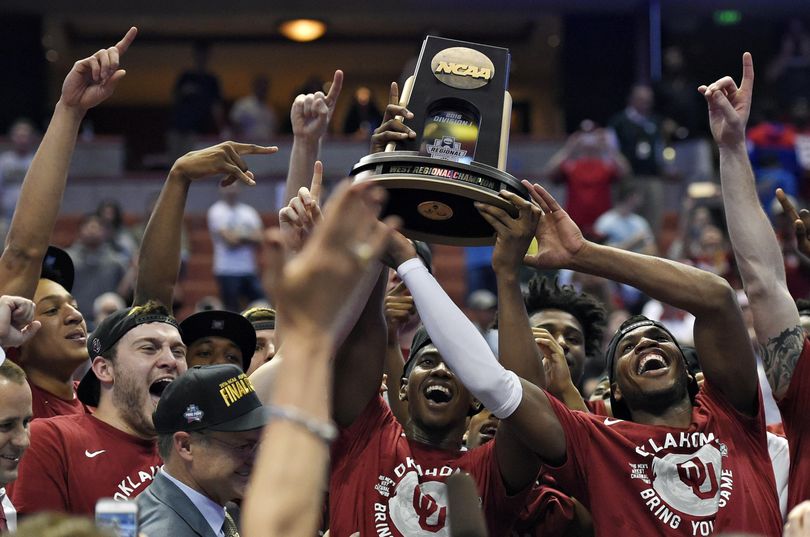 Oklahoma guard Buddy Hield holds the trophy as he and his teammates celebrate their win over Oregon. (Mark J. Terrill / Associated Press)