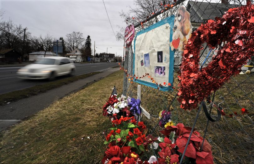 Traffic moving south on Ash Street flashes past a memorial for Susette G. Werner at the corner with Maxwell Avenue on Monday. (Christopher Anderson / The Spokesman-Review)