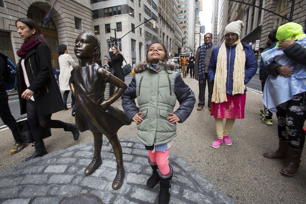 Shriya Gupta of Cherokee, N.C., strikes a pose with a statue titled “Fearless Girl,” Wednesday, March 8, 2017, in New York. The statue was installed by an investment firm in honor of International Women’s Day. (Mark Lennihan / Associated Press)
