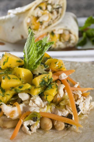 Thai-style chicken wraps with mango are easy to eat.  While maintaining a level of sophistication these wraps are great for a dinner alfresco. (Associated Press)
