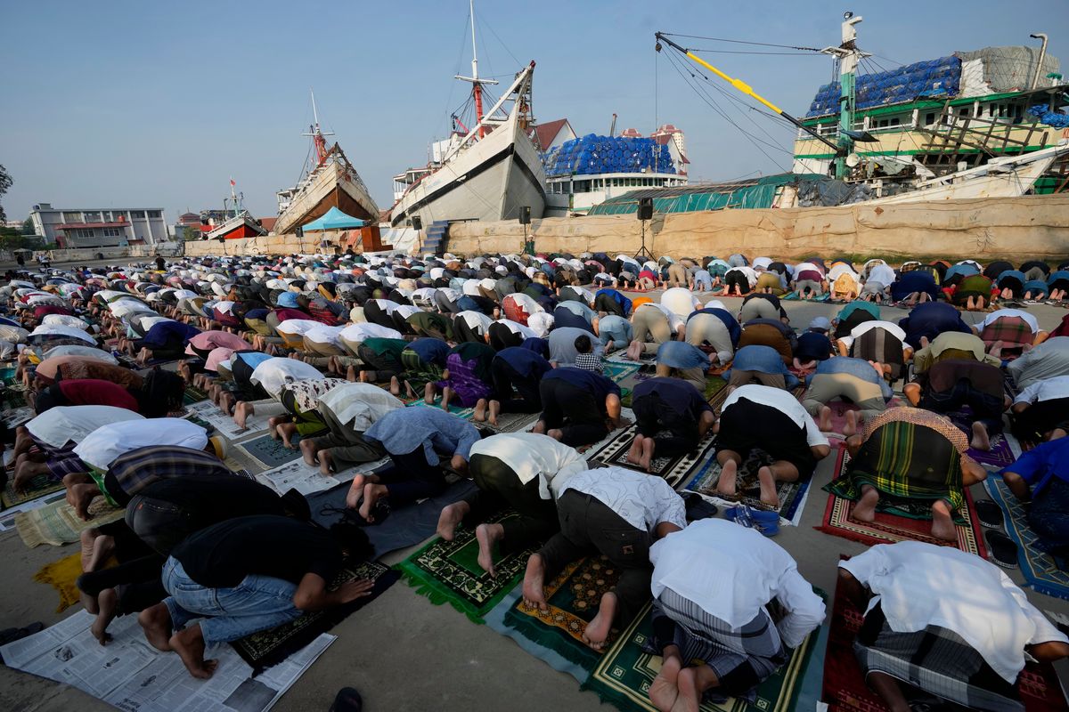 Muslim men offer Eid al-Fitr prayers to mark the end of the holy fasting month of Ramadan at Sunda Kelapa port in Jakarta, Indonesia, Monday, May 2, 2022.  (Tatan Syuflana)