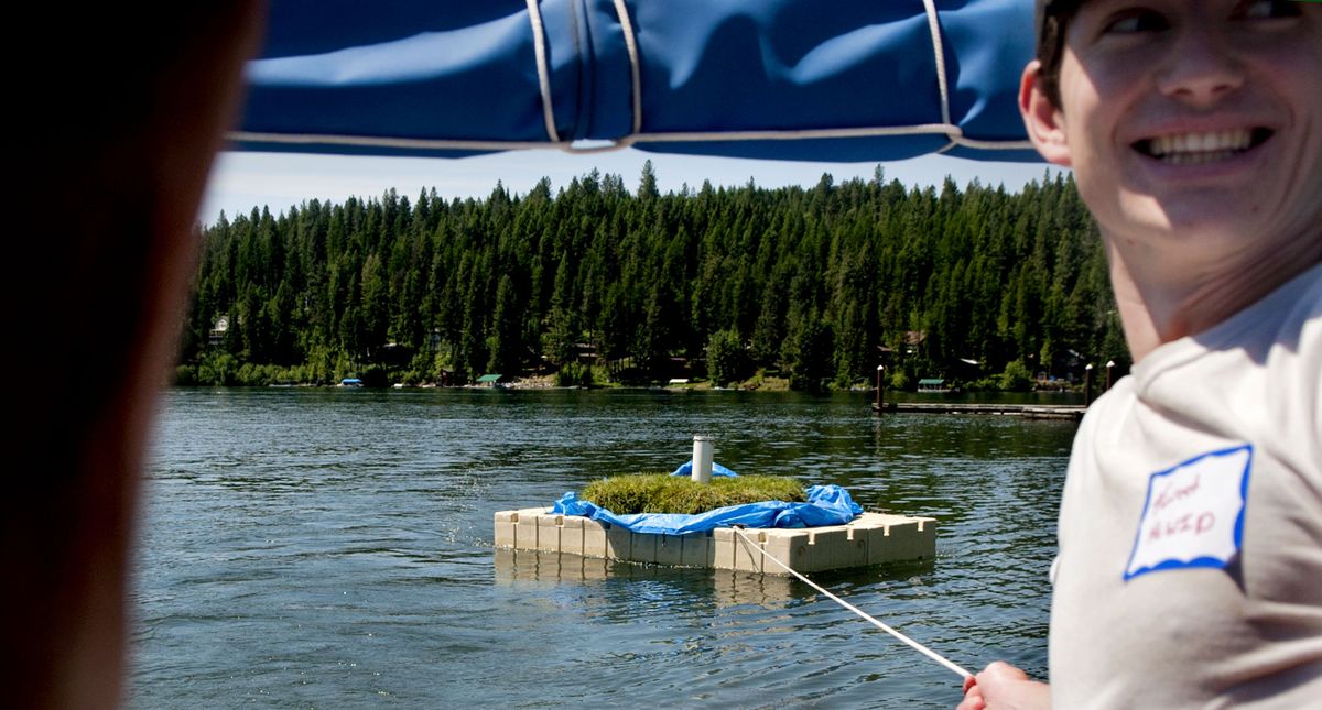 Forrest Walker of Hayden Lake Watershed Improvement District holds onto a floating wetland as it is towed to a bay in the northeast corner of Hayden Lake on Friday. Kootenai Environmental Alliance is launching eight floating wetlands in bays around Hayden Lake this year. (Kathy Plonka)