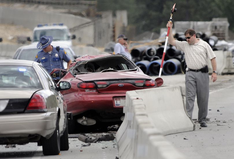Investigators examine a crash scene June 20 on U.S. Highway 395. The driver of the red car was killed. (Dan Pelle)