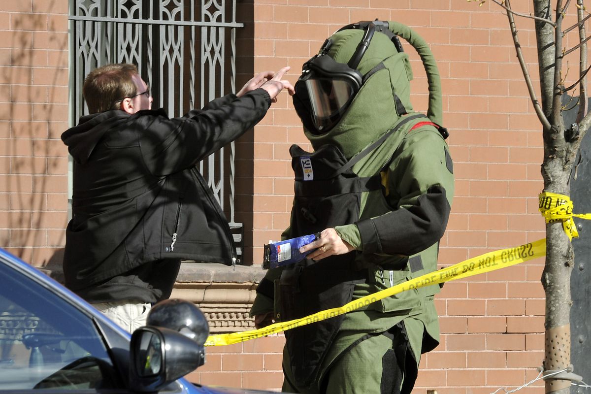 A member of the Spokane Explosive Disposal Unit holds paper packaging found in a device left at the front counter of the Spokesman-Review, May 5, 2011, in downtown Spokane, Wash.  The package was moved to a shipment receiving bay when the officer inspected the device. (Dan Pelle / The Spokesman-Review)