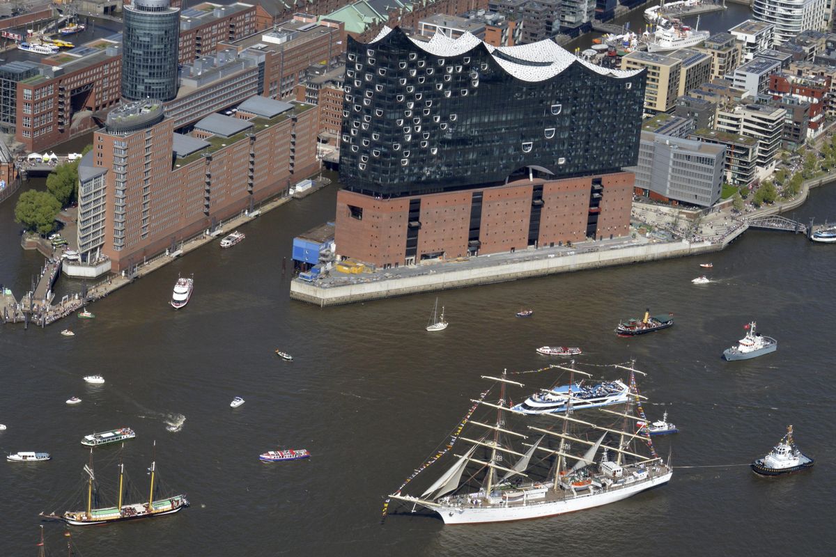 Tall ships pass by the Elbphilharmonie building in  Hamburg, northern Germany, harbor in 2016. “Second cities”  are less expensive and less crowded. (Frank Bruendel / AP)