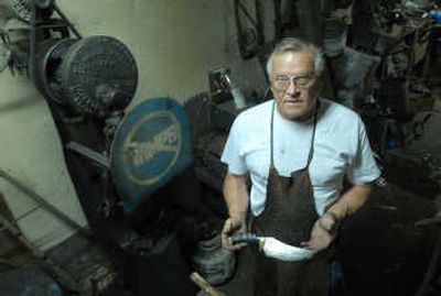 
Ray Rantanen stands in his workshop with a Damascus steel knife he made.
 (The Spokesman-Review)