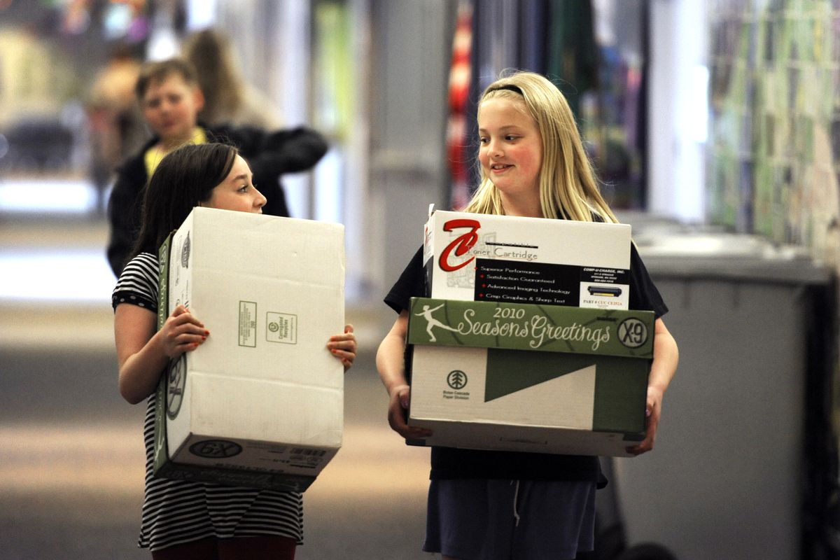 Evie Wehrlie, left, and Destanee Wilson carry boxes of recyclable printer cartridges down the halls at Broadway Elementary on Thursday, April 12, 2012.  The girls were helping teacher Darren Herndon with his recycling program, which has raised thousands of dollars over the past several years. (Jesse Tinsley / The Spokesman-Review)