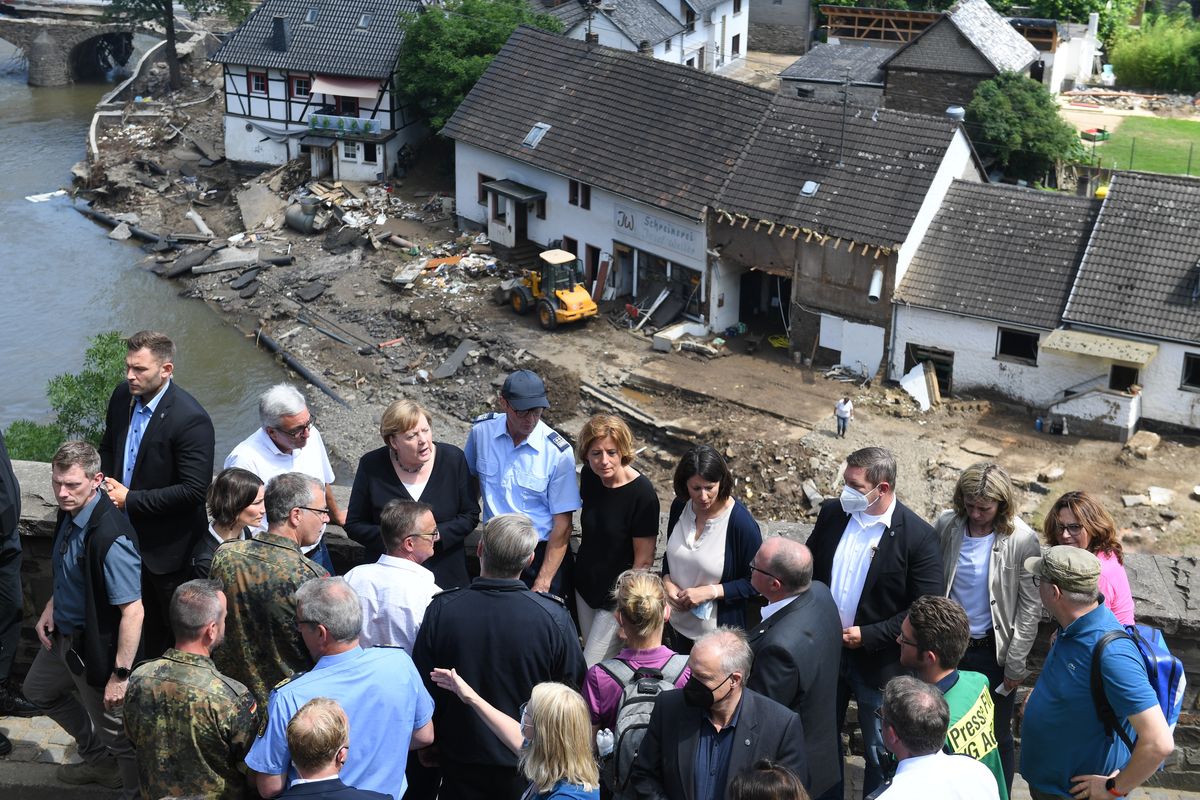 German Chancellor Angela Merkel, rear third left, and the Governor of the German state of Rhineland-Palatinate, Malu Dreyer, rear fifth left, are seen on a bridge in Schuld, western Germany, Sunday, July 18, 2021 during their visit in the flood-ravaged areas to survey the damage and meet survivors. After days of extreme downpours causing devastating floods in Germany and other parts of western Europe the death toll has risen.  (Christof Stache)