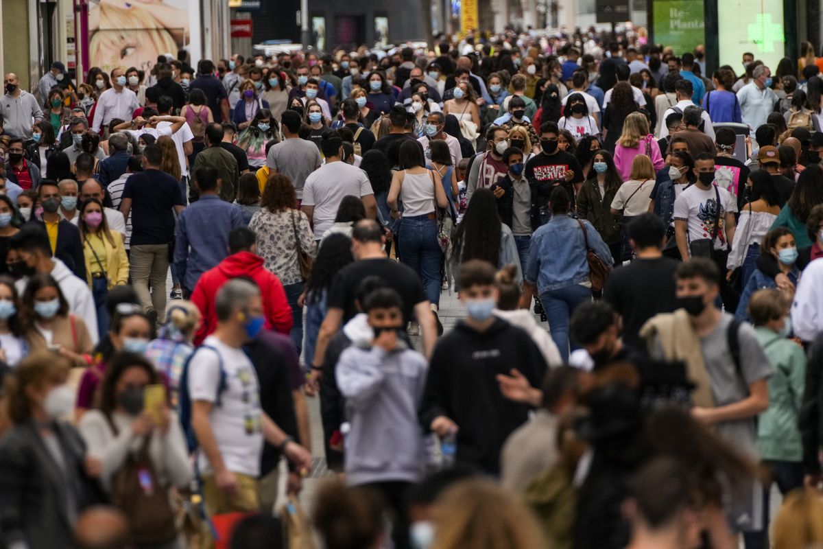 In this June 5, 2021 photo, people wearing face masks to protect against the spread of coronavirus, walk along a commercial street in downtown Madrid, Spain. Countries across Europe are scrambling to accelerate coronavirus vaccinations to outpace the spread of the delta variant in a high-stakes race to prevent hospital wards from filling up again with patients fighting for their lives. (Manu Fernandez)