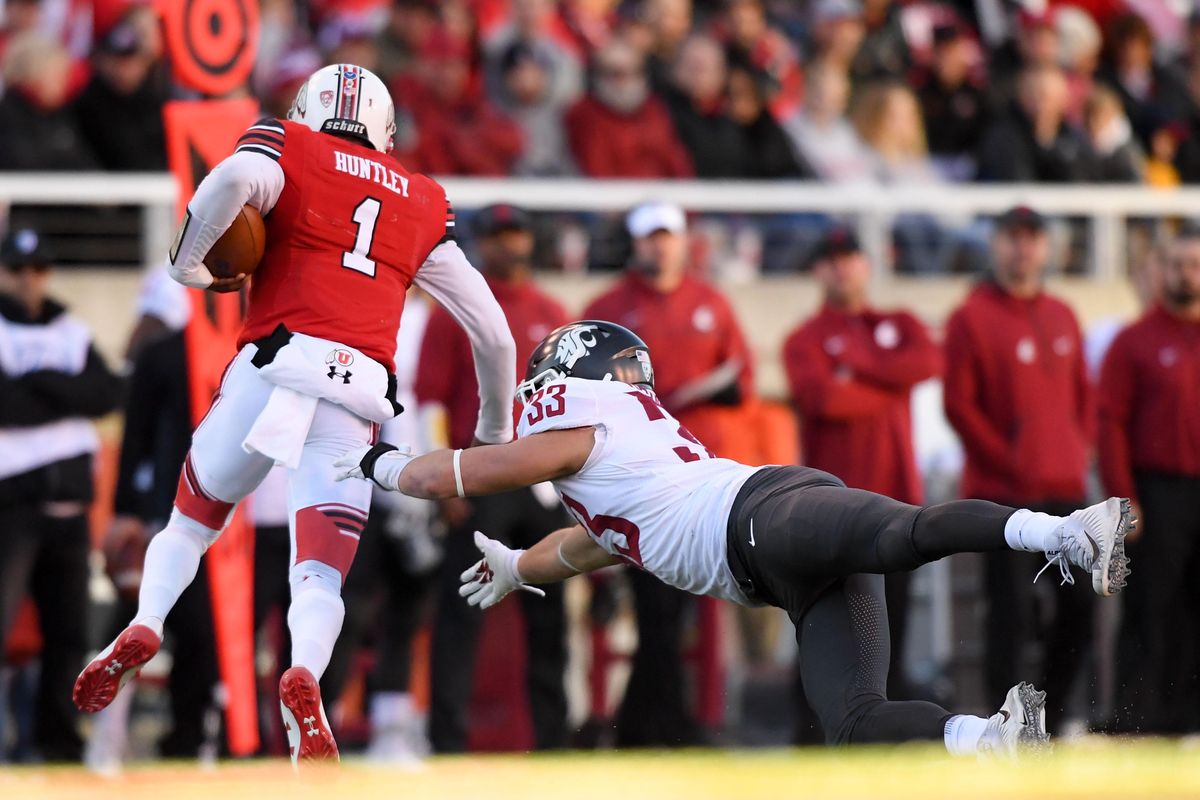 Utah Utes quarterback Tyler Huntley (1) slips a tackle from Washington State Cougars linebacker Dylan Hanser (33) during the first half of a college football game on Saturday, November 11, 2017, at Rice-Eccles Stadium in Salt Lake City, Utah. (Tyler Tjomsland / The Spokesman-Review)