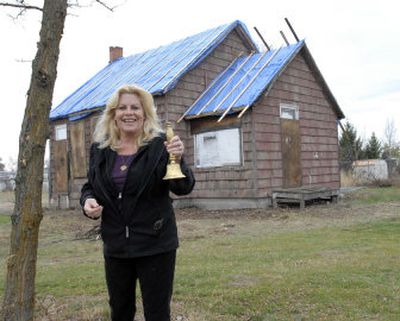 
Spokane Valley Heritage Museum Curator Jayne Singleton stands next to the Lone Fir school house, a one-room relic from the Valley's early days. She is holding the bell which teacher Tella Morgan used when it was Central Valley's only kindergarten class back in 1950. The structure will be moved behind the museum in the spring. 
 (J. BART RAYNIAK / The Spokesman-Review)