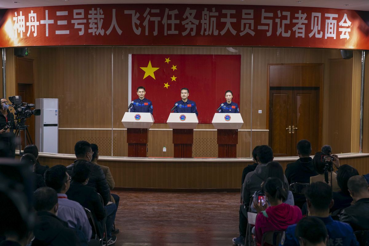 In this photo released by Xinhua News Agency, Chinese astronauts, from left, Ye Guangfu, Zhai Zhigang and Wang Yaping meet the reporters at a press conference at the Jiuquan Satellite Launch Center ahead of the Shenzhou-13 launch mission from Jiuquan in northwestern China, Thursday, Oct. 14, 2021. China is preparing to send three astronauts to live on its space station for six months — a new milestone for a program that has advanced rapidly in recent years.  (Ju Zhenhua)