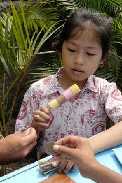 
An Indonesian girl buys a sweet rice treat during lunch recently outside her school in Jakarta, Indonesia. 
 (Associated Press / The Spokesman-Review)