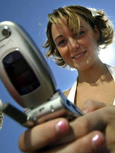 
Sixteen-year-old Tory Jones uses the text messaging function on a cell phone to message a friend from a park in Broomfield, Colo., before going back to school. Cell phone companies are marketing their prepaid plans to the younger generation, and finding success. 
 (File/Associated Press / The Spokesman-Review)