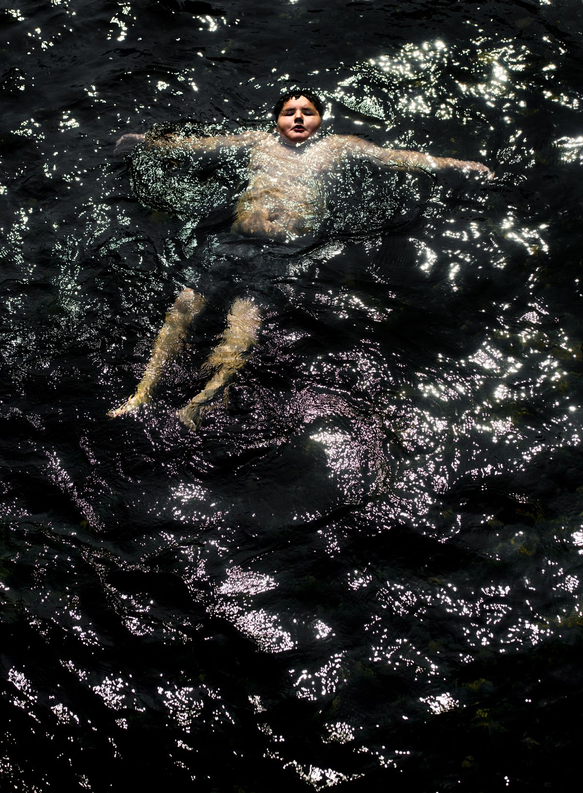 With the thermometer punching above 100 degrees, Takoda Bearchild, 10, stays cool as he  floats down the Little Spokane River in Pine River Park, Thursday, Aug. 9, 2018. (Colin Mulvany / The Spokesman-Review)