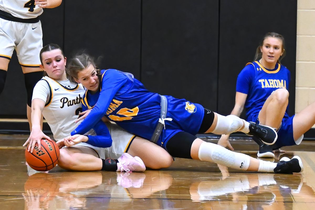 Mead guard Miah Cyr (2) scrambles for a loose ball with Tahoma center Adalynn Busch (on right) during a Fitz Tournament girls high school basketball game held at Lewis and Clark High School, Friday December 2, 2022.  (Colin Mulvany/The Spokesman-Review)