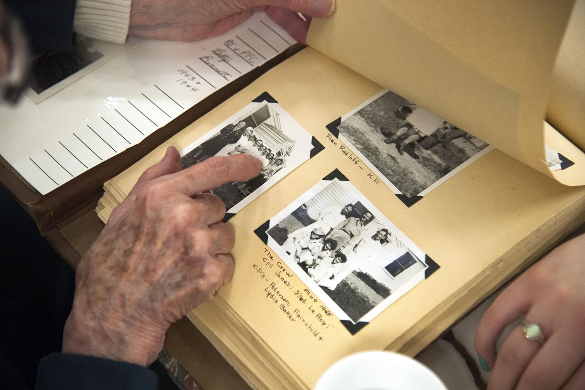 Betty Graham shows pictures from her days in the Women’s Army Corps to Eisaya Cook and Haley Davis during an interview session Friday at Harvard Park in Spokane, Wash. Students from Central Valley School District’s Barker High School and Spokane Valley Tech interviewed members of the WWII generation. (Dan Pelle / The Spokesman-Review)