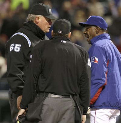 Texas Rangers manager Ron Washington, right, argues a call with umpires Ted Barrett (65) and Paul Schrieber during the sixth inning. (Associated Press)