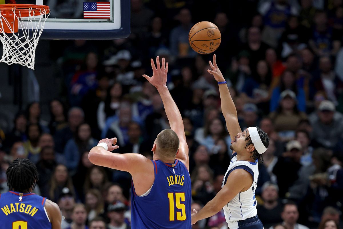 Dallas guard Ryan Nembhard throws up a shot against Denver’s Nikola Jokic at Ball Arena on Monday in Denver.  (Getty Images)