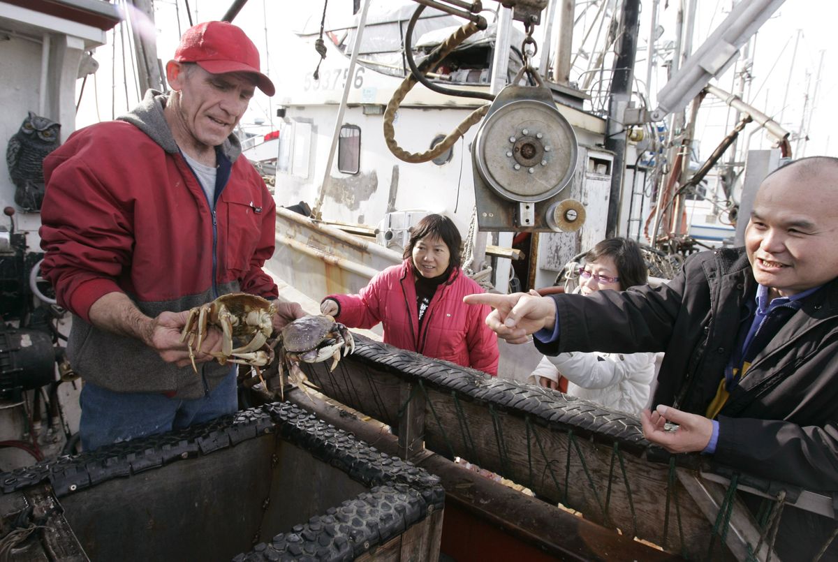 Commercial fisherman Duncan MacLean, left, negotiates with customer Walton Yee for crabs MacLean had just caught in Half Moon Bay, Calif., on Dec. 3.   Associated Press photos (Associated Press photos / The Spokesman-Review)