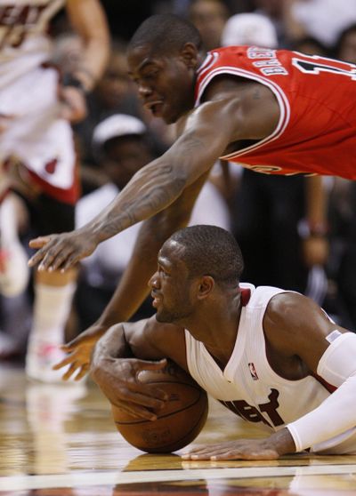 Miami’s Dwyane Wade keeps the ball away from Chicago’s Ronnie Brewer. (Associated Press)
