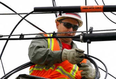 
Verizon lineman Clemente Calma installs fiber-optic cable on a telephone pole in Massapequa Park, N.Y. Verizon is alone among the major phone companies in severing copper lines from telephone poles to residences. This cuts off a resident's ability to switch back to regular phone service or any service that uses copper, such as DSL, a cheaper high-speed Internet connection. Associated Press
 (Associated Press / The Spokesman-Review)