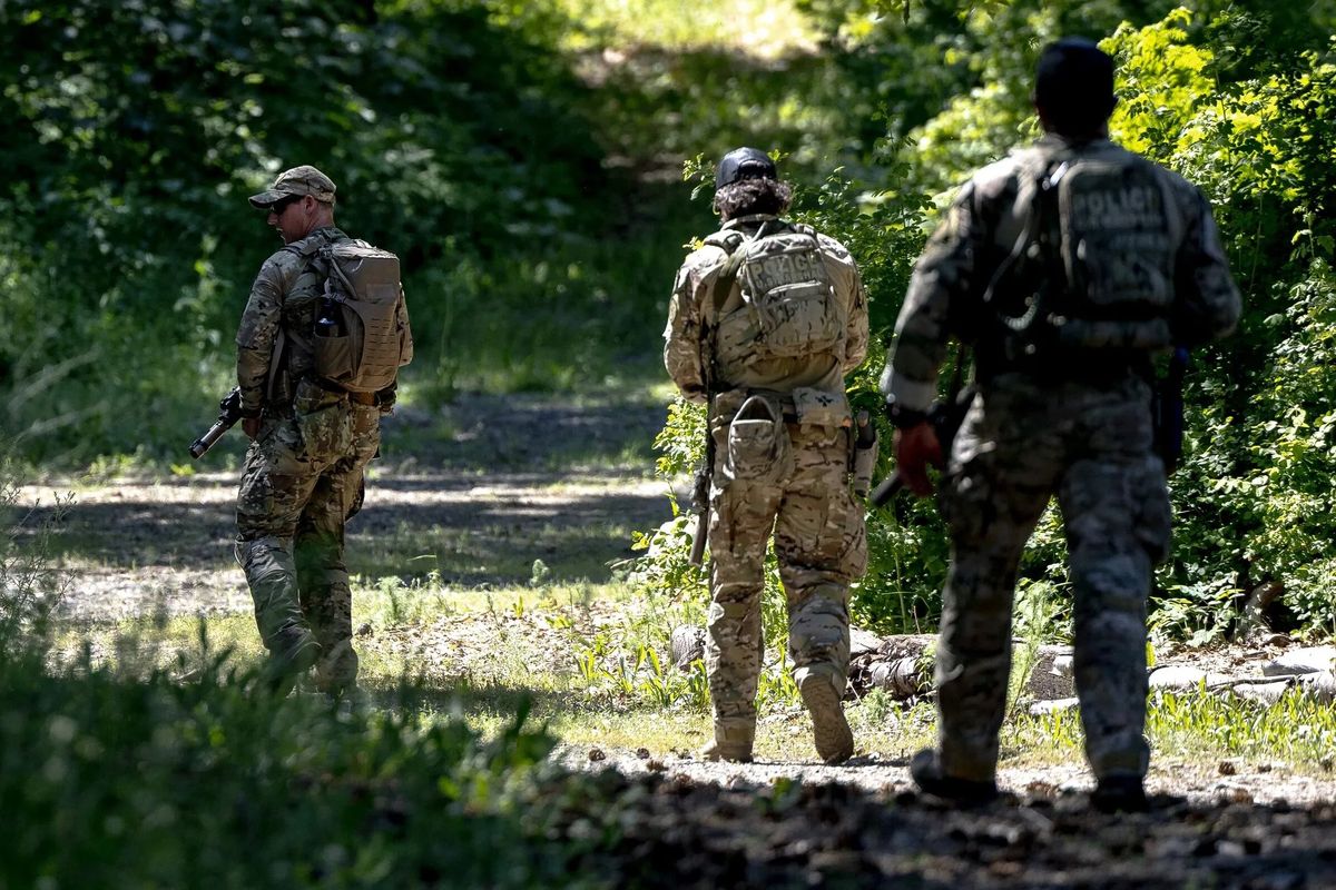 Federal agents search for Travis Decker earlier this month, near Peshastin, Wash. Cadaver dogs have since joined the search for Decker, with authorities believing that he could possibly have died in the wilderness. (Nick Wagner/Seattle Times)