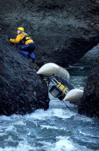 
A rescue worker tries to free a cataraft stuck between two rock formations near the Bowl and Pitcher area in Riverside State Park on Saturday afternoon. No one was hurt when three boaters were floating the Spokane River and one got stuck. 
 (Holly Pickett / The Spokesman-Review)