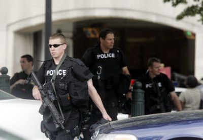
Heavily armed police officers walk from the garage of the Rayburn House Office building, seen at rear, after they responded to a report of gunfire on Capitol Hill on Friday. The report proved false. 
 (Associated Press / The Spokesman-Review)