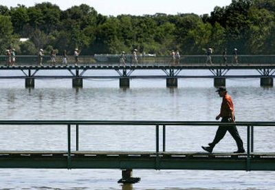 
Phil Mickelson walks across a bridge spanning Lake Kadijah to the 13th green at Medinah Country Club. 
 (Associated Press / The Spokesman-Review)