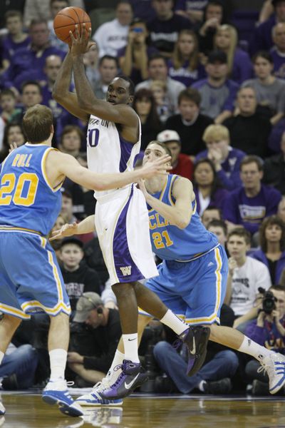 Washington’s Quincy Pondexter looks to pass as UCLA’s Michael Roll, left, and Brendan Lane defend. (Associated Press)