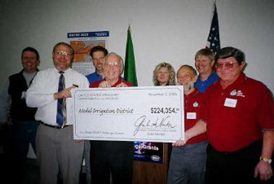
Model Irrigation District employees and members along with Bureau of Reclamation's Bill McDonald, second from left, pose with the grant check. Employees and members are, from left, Rick Neal,  Tim Schudel, V. Lennie Husa, Diane Doran, Lynn Plaggemeier, Jim Lahde and Gerald Manfred.  
 (Courtesy of Jim Lahde / The Spokesman-Review)