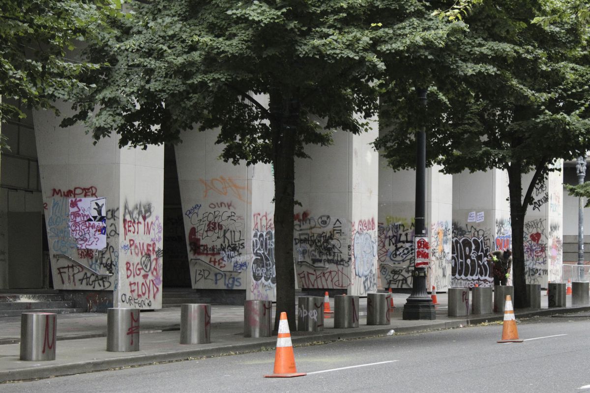 Graffiti from recent demonstrations covers pillars outside of the Mark O. Hatfield Federal Courthouse in downtown Portland, Ore., on Wednesday, July 8, 2020. Protesters who have clashed with authorities in Portland, Ore., are facing off not just against city police but a contingent of federal agents who reflect a new priority for the Department of Homeland Security: preventing what President Donald Trump calls "violent mayhem." The agents clad in military-style uniforms include members of an elite Border Patrol tactical unit, and their deployment to protect federal buildings and monuments is a departure for an agency created to focus on threats from abroad.  (Gillian Flaccus)