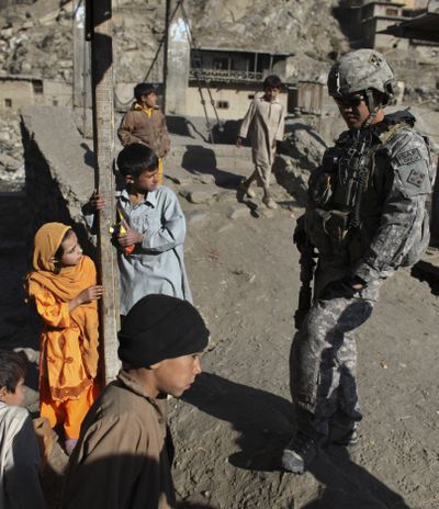Afghan children and a U.S. Army soldier try to communicate during a joint U.S.-Afghan Army patrol in Kandilak, a village in the Pech Valley, Kunar province, northeastern Afghanistan, on Thursday.  (Associated Press / Associated Press)