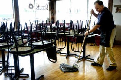 
Owner Mike Britton mops at Mike's Old Fashioned Donuts Friday afternoon. 
 (Holly Pickett / The Spokesman-Review)