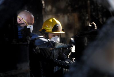 Fire investigators Jimmy Bowen, left, and Jason Reser examine a warehouse after a fire Wednesday in north Spokane.  (Kate Clark / The Spokesman-Review)
