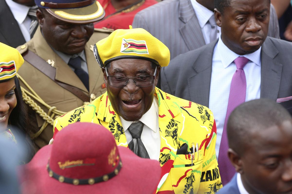 In this Wednesday, Nov. 8, 2017 photo, Zimbabwean President Robert Mugabe, centre, arrives for a solidarity rally in Harare. Armored personnel carriers were seen Tuesday Nov. 14, 2017, outside the capital a day after the army commander Chiwenga threatened to "step in" to calm political tensions over the president