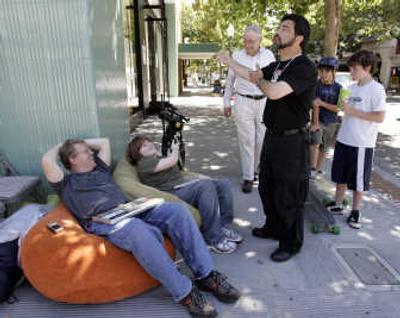 
Apple store assistant manager Erez Saldinger, right, welcomes back Robert Scoble, left, and his son, Patrick, 13, center, after Apple told them earlier to leave during their wait in Palo Alto, Calif., Thursday. Associated Press
 (Associated Press / The Spokesman-Review)