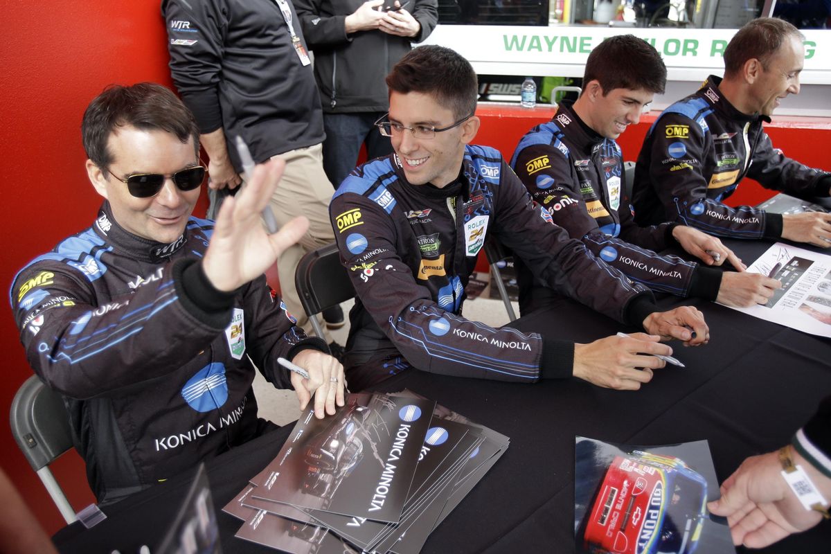 Jeff Gordon, left, waves as he and co-drivers, from second left, Jordan Taylor, Ricky Taylor and Max Angelelli, of Italy, sign autographs for fans before the IMSA 24-hour auto race at Daytona International Speedway, Saturday, Jan. 28, 2017, in Daytona Beach, Fla. (John Raoux / Associated Press)