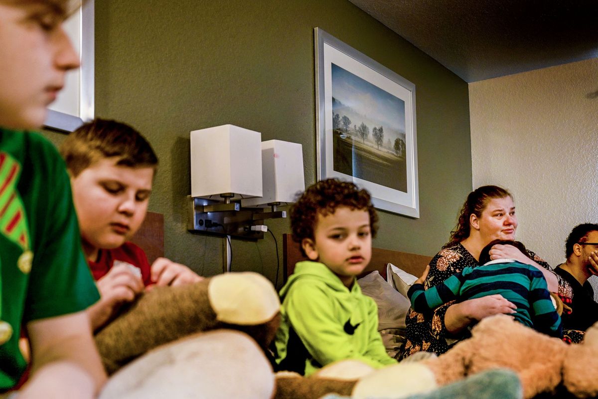 Katie Vozzy, second from right, holds her son Julian Vozzy, 7, while talking about the difficulties of being evicted after spending several months in and out of the hospital.  (Kathy Plonka/The Spokesman-Review)