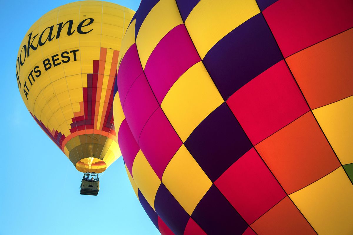 Forey Walter’s "Spokane At Its Best" hot air balloon and Bill Woodhead’s WWJD balloon, take to the sky during launch on Sept. 24, 2016, at Valleyfest. (Dan Pelle / The Spokesman-Review)