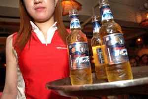 
A waitress totes some bottles of beer to patrons during a busy evening at a restaurant in China. Major brewers are showing a keen interest in the growing Chinese market.
 (Associated Press / The Spokesman-Review)