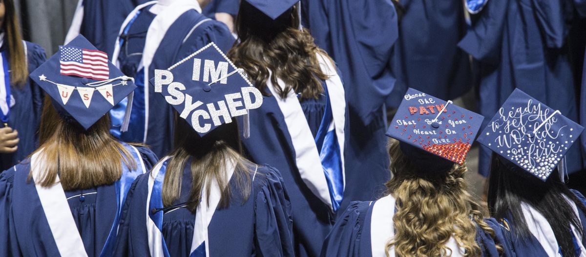 GU students gather back stage, with messages on their mortar boards, for the Gonzaga University 124th commencement, May 14, 2017, in the Spokane Arena. (Dan Pelle / The Spokesman-Review)
