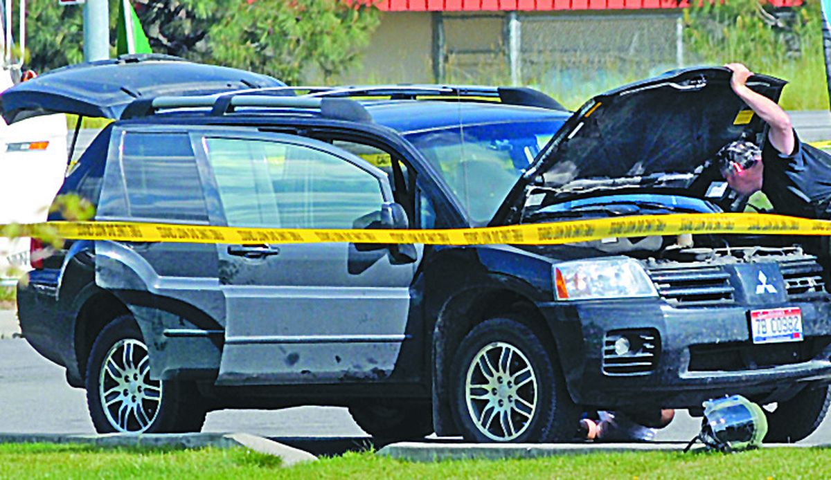 Local authorities conduct a search of the vehicle after  a pipe bomb was removed at the Fast Lane Quick Lube in Coeur d’Alene on Tuesday.  (Kathy Plonka)